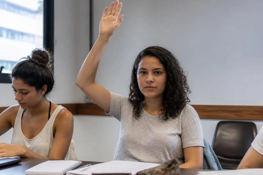 Facilitador em pé apontando para um argumento escrito no quadro durante a sessão
